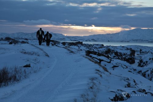 Divers walking through the snow at Silfra during the wintertime.