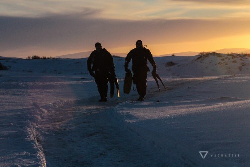 Dry suit divers walk back through the snow at Thingvellir.